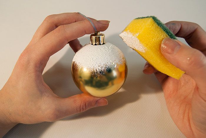 Новогодишна топка със сняг се получава, ако основата е плътно покрита с PVA лепило и оваляна в сол и искри. Вторият метод е бяла акрилна боя: тя се нанася с гъба върху играчката.